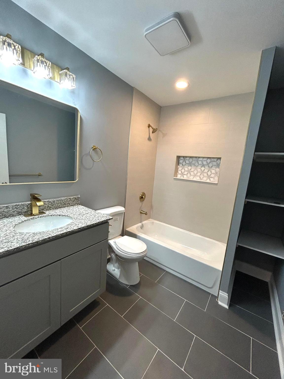 3902 West Rogers Avenue, Unit 2 Baltimore, MD 21215 - Photo 13 of 15 a bathroom with a granite countertop sink toilet and shower