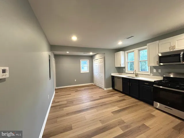 a large kitchen with kitchen island granite countertop a sink window and stainless steel appliances