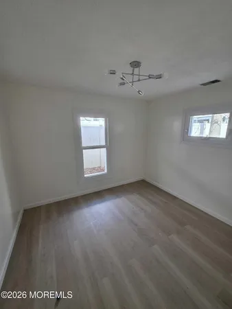 an empty room with a window and ceiling fan