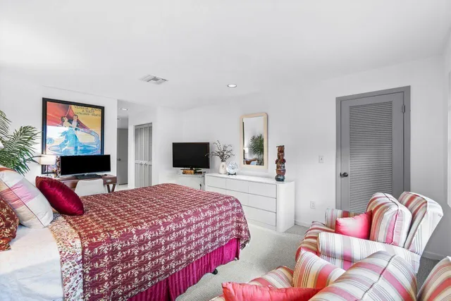 a bedroom with a bed and flat screen tv