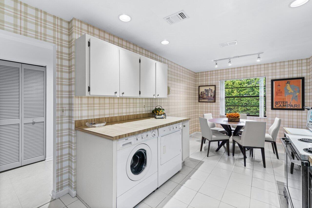 20 Westgate Lane, Unit B Boynton Beach, FL 33436 - Photo 16 of 46 a kitchen with a stove a sink a dining table and chairs
