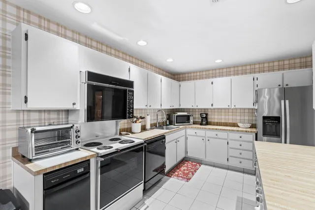 a kitchen with a sink stove top oven and refrigerator
