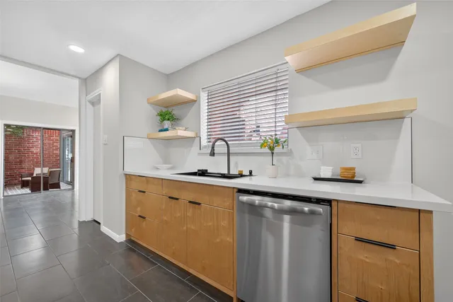 a view of a hallway with wooden floor and a kitchen