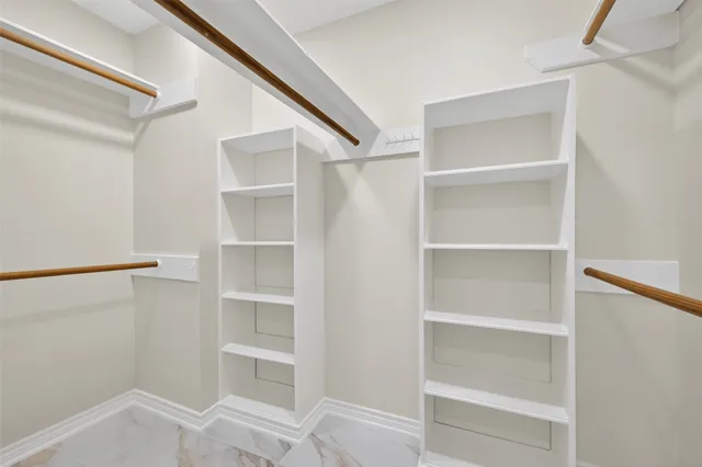 a view of walk in closet with empty racks