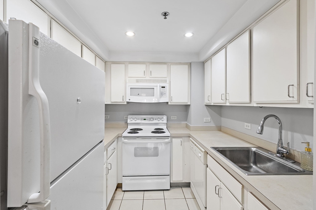 534 Commonwealth Avenue, Unit 3A Boston, MA 02215 - Photo 6 of 18 a kitchen with white cabinets sink and white appliances