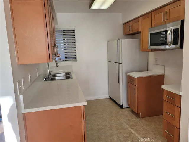 a view of a kitchen with a sink and a refrigerator