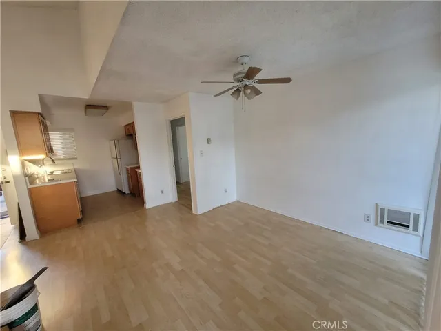 a view of an empty room with wooden floor and windows