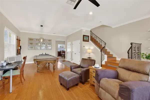 a dining room with furniture and a chandelier fan