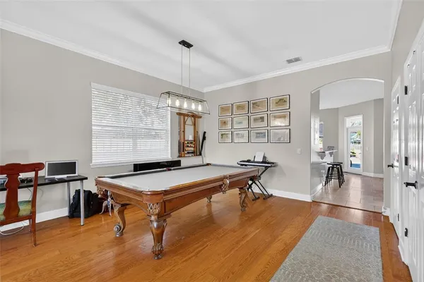 a kitchen with stainless steel appliances granite countertop a table chairs and a refrigerator