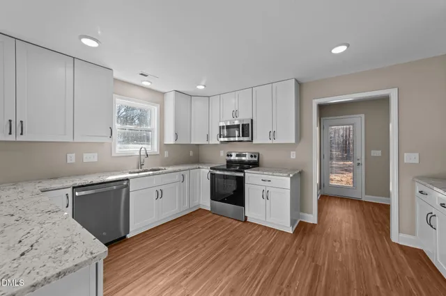 a kitchen with wooden floors and white appliances