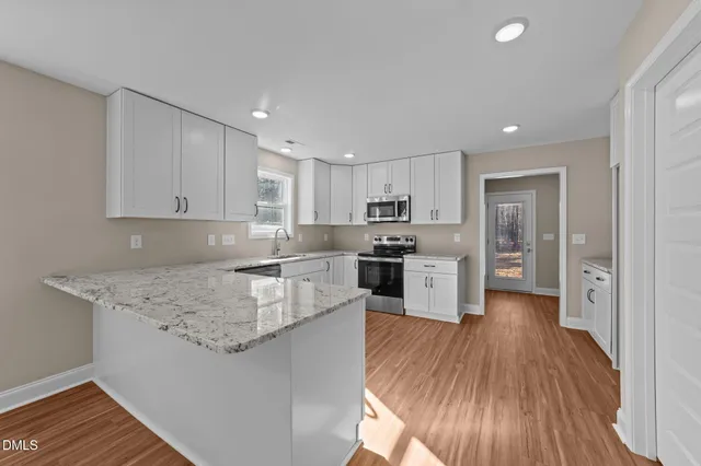 a kitchen with stainless steel appliances granite countertop a stove a sink and a refrigerator