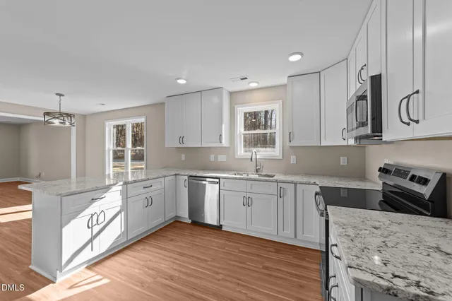 a kitchen with granite countertop a stove sink and cabinets
