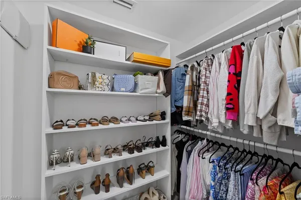 a view of walk in closet with clothes and shoes