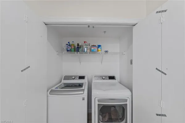 a view of washer and dryer with kitchen in the background