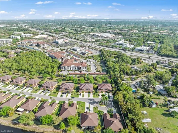 an aerial view of residential houses with outdoor space and trees