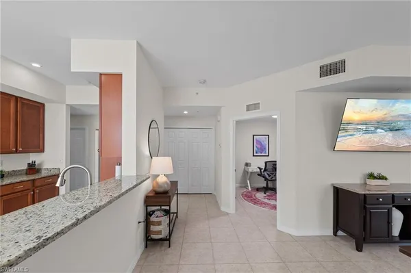 a kitchen with granite countertop a sink and a refrigerator