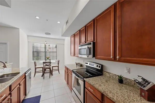 a kitchen with stainless steel appliances granite countertop a stove a sink and a microwave
