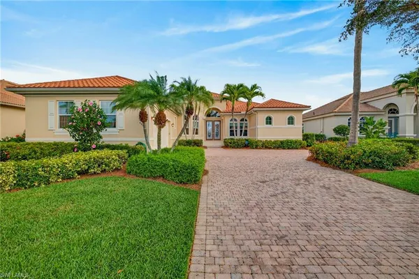 a front view of a house with a yard and potted plants