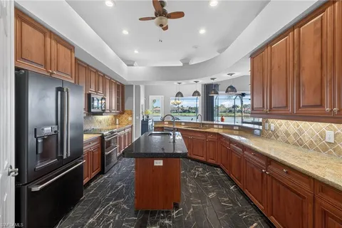 a kitchen with stainless steel appliances granite countertop a sink a stove and a refrigerator