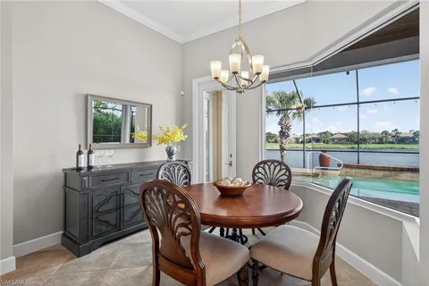 a dining room with furniture a chandelier and window