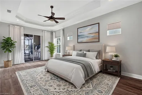 a view of an empty room with wooden floor ceiling fan