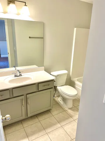 a bathroom with a sink a toilet and mirror