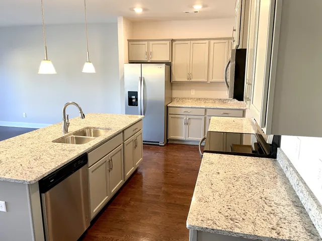 a kitchen with a sink refrigerator and microwave