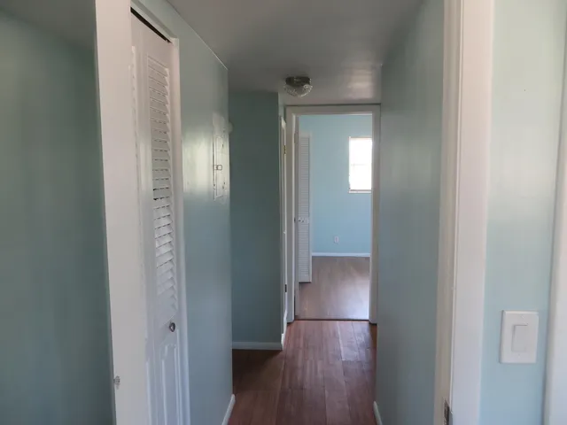 a view of an empty room with closet and wooden floor