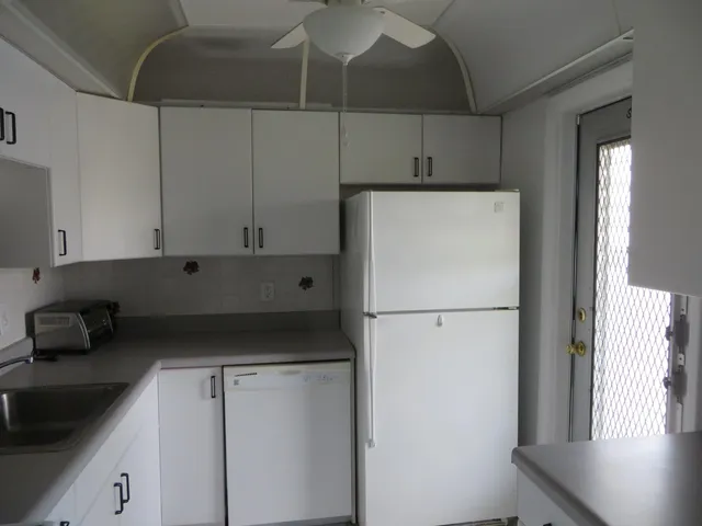 a kitchen with refrigerator and cabinets