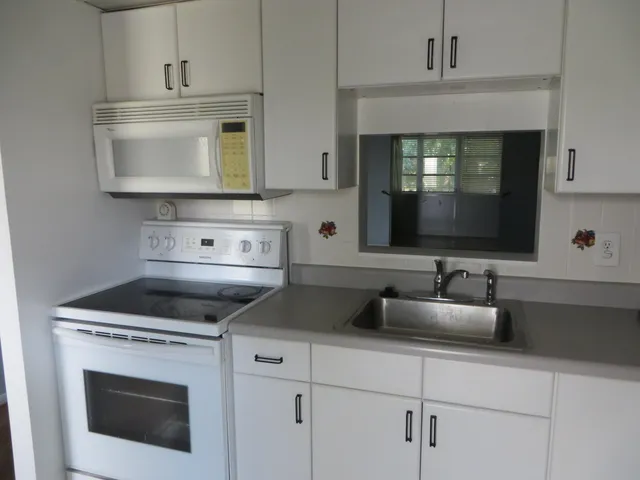 a kitchen with a stove microwave and sink