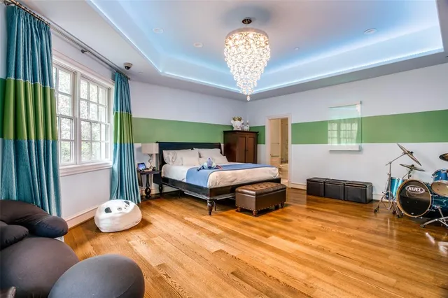 a kitchen with stainless steel appliances a stove a sink dishwasher a refrigerator with white cabinets and wooden floor