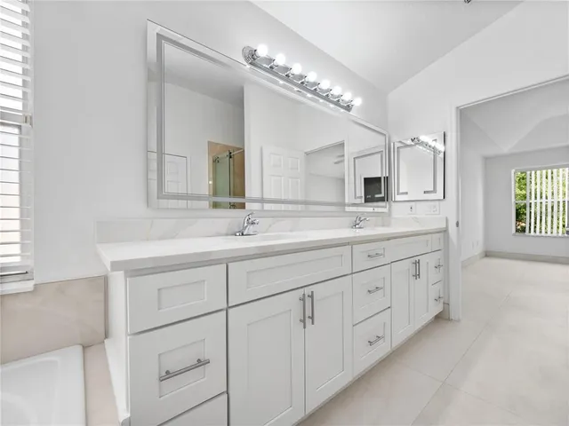 a spacious bathroom with double sink and a mirror