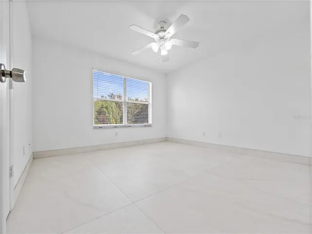 an empty room with a window and a ceiling fan