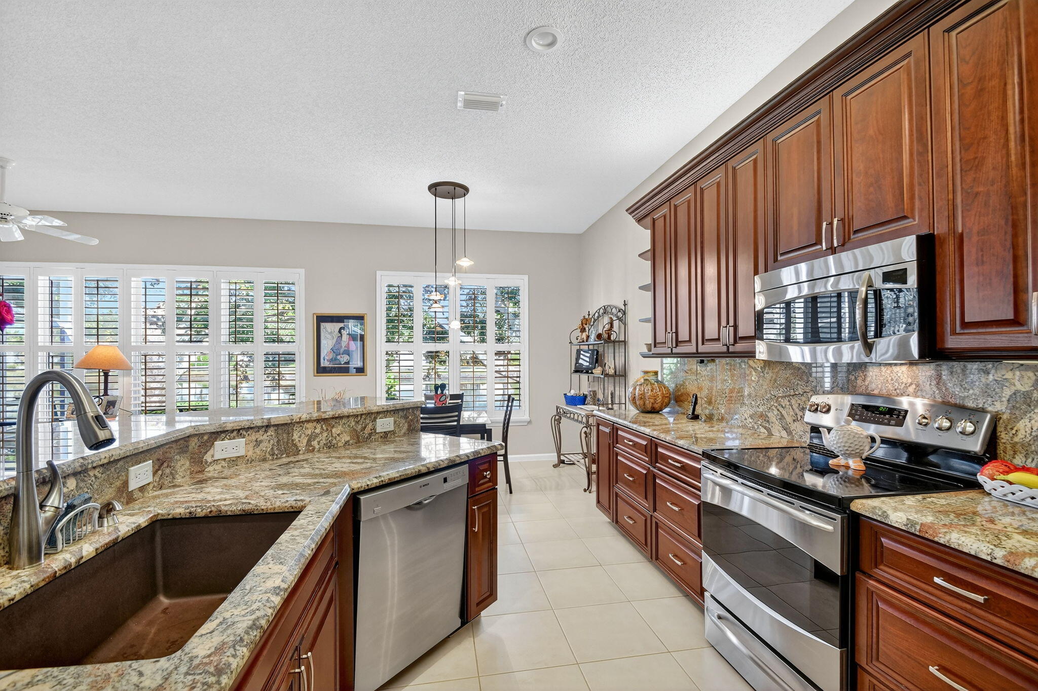 7811 Rockford Road Boynton Beach, FL 33472 - Photo 7 of 72 a kitchen with granite countertop a sink stainless steel appliances and cabinets