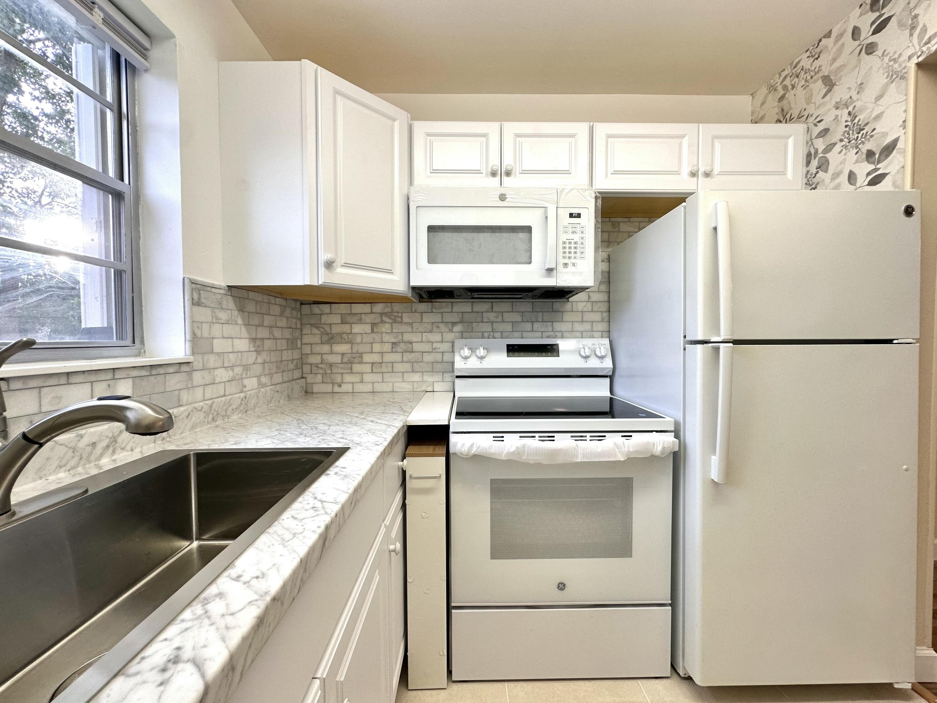 47 Camden B West Palm Beach, FL 33417 - Photo 17 of 36 a kitchen with a refrigerator and a sink