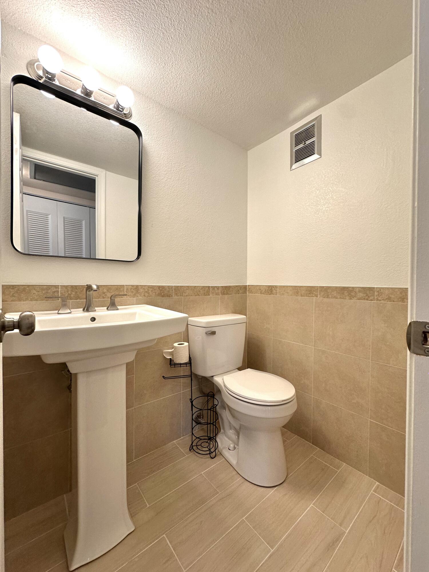 47 Camden B West Palm Beach, FL 33417 - Photo 18 of 36 a bathroom with a sink toilet and mirror