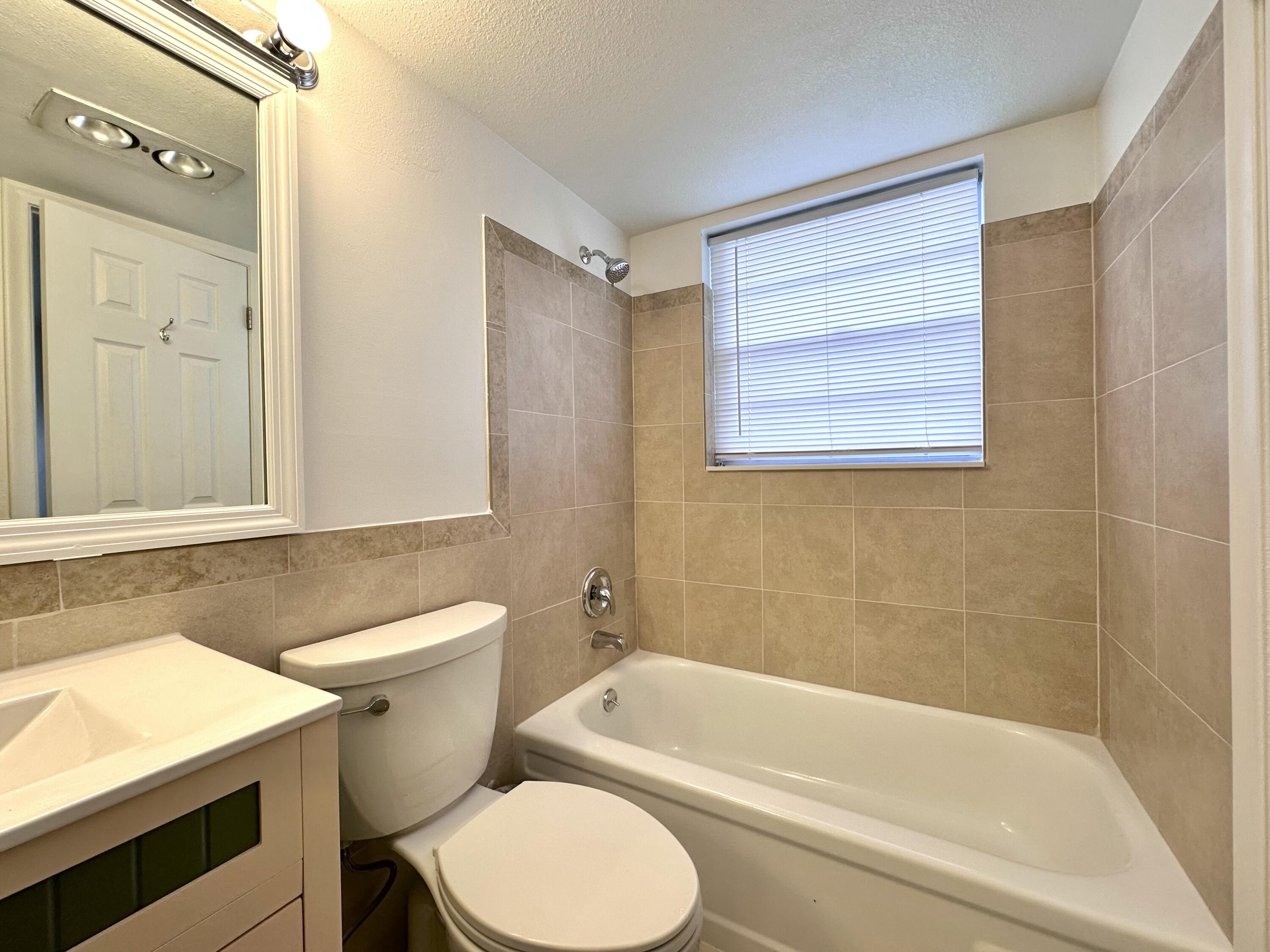 47 Camden B West Palm Beach, FL 33417 - Photo 22 of 36 a bathroom with a toilet a sink and bathtub