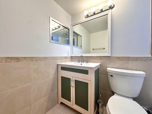 a bathroom with a toilet sink and mirror
