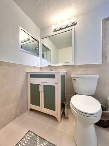 a bathroom with a toilet a sink and mirror