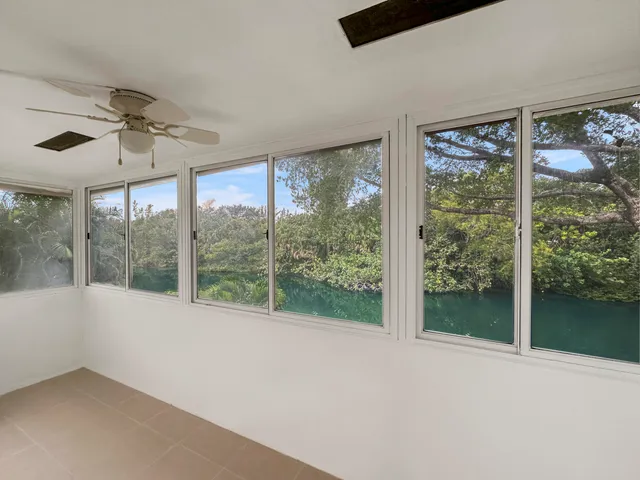 a view of an empty room with a window and a ceiling fan