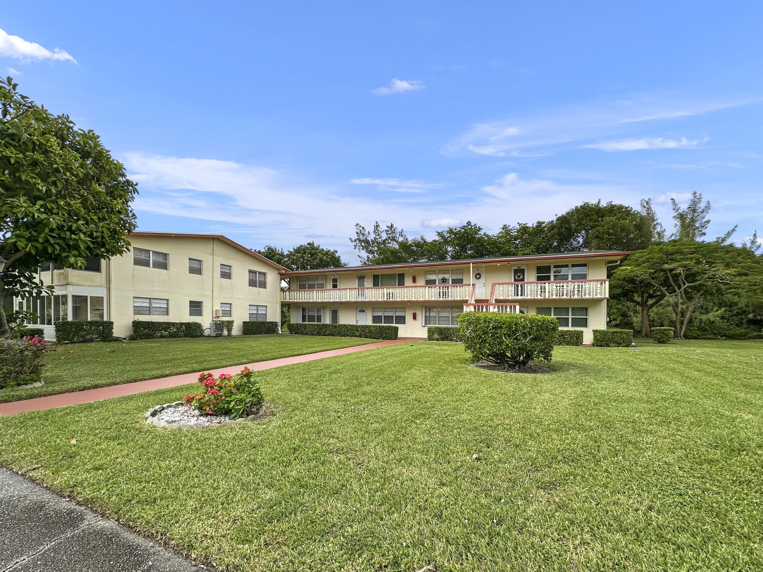 47 Camden B West Palm Beach, FL 33417 - Photo 4 of 36 a front view of a house with a yard table and chairs