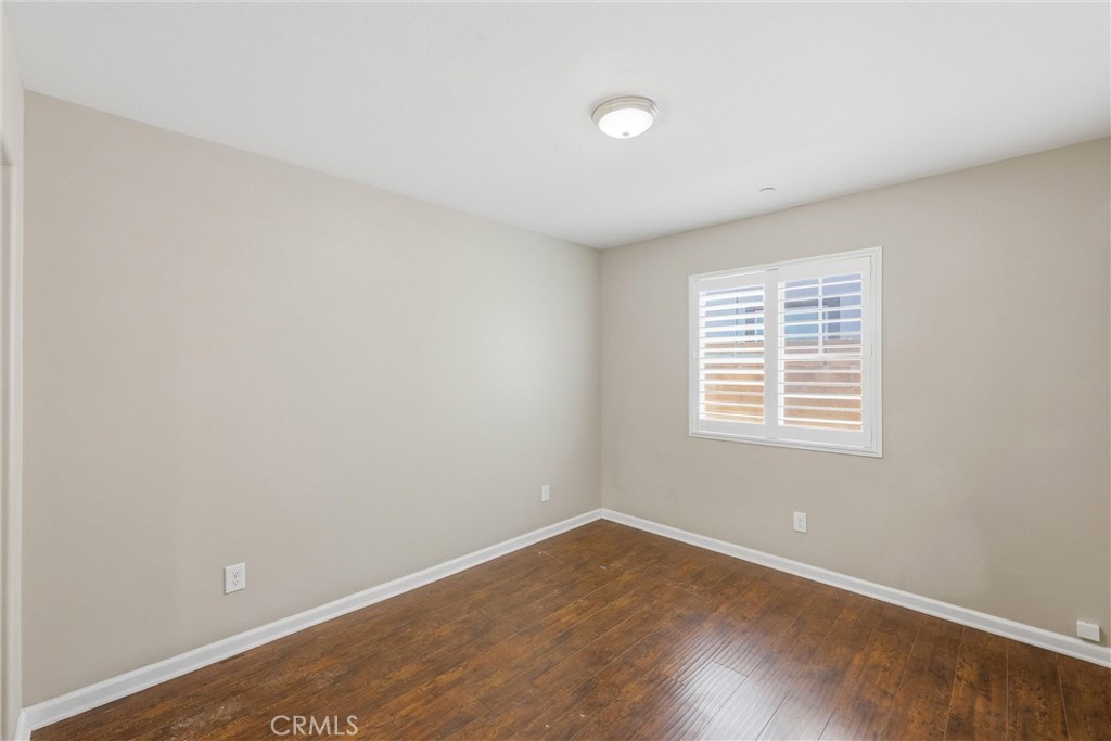 956 West Tibbot Street Rialto, CA 92377 - Photo 7 of 37 an empty room with wooden floor and windows