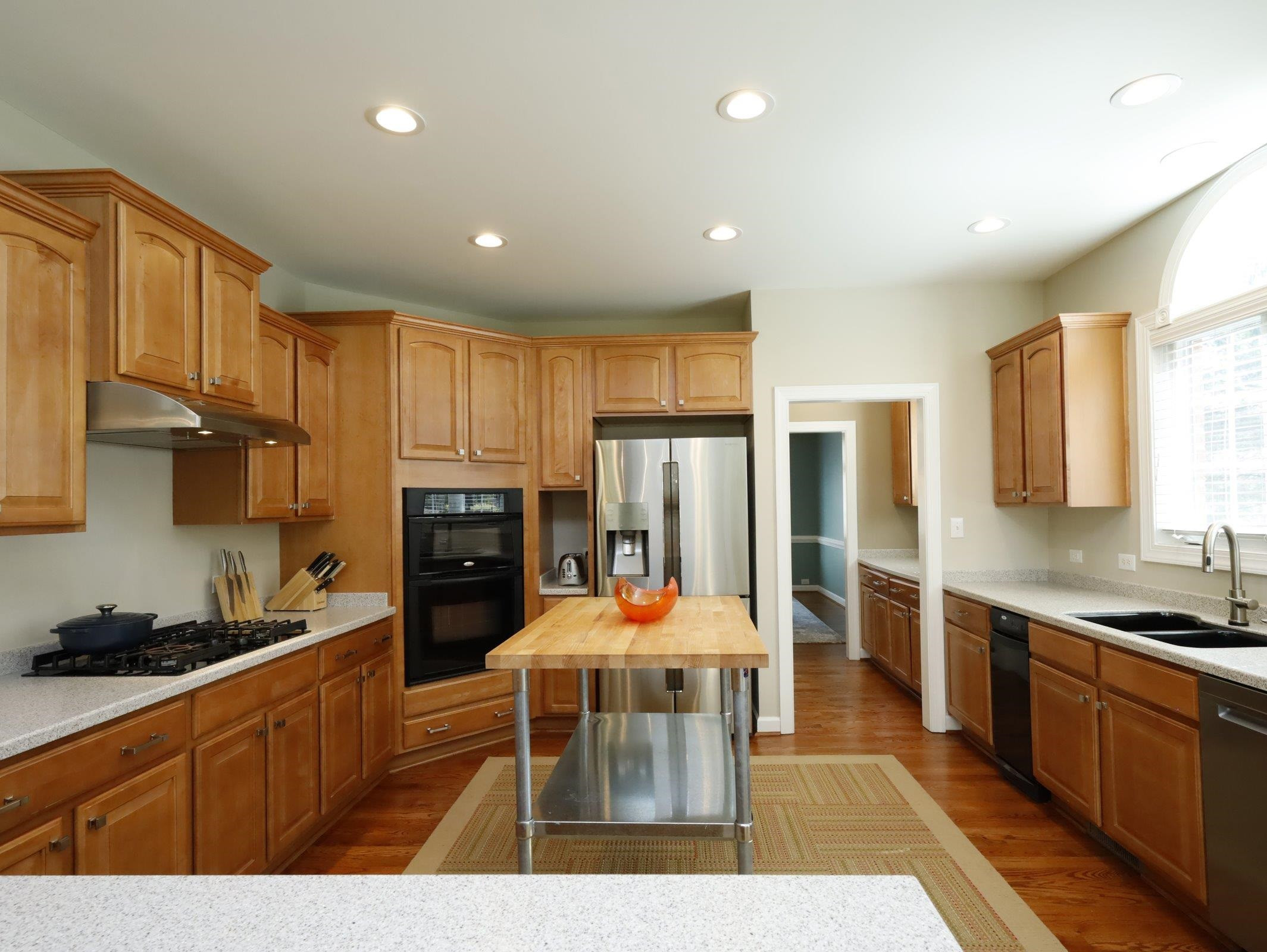 2565 Bittersweet Drive Durham, NC 27705 - Photo 19 of 37 a kitchen with stainless steel appliances kitchen island granite countertop a refrigerator a stove top oven and a dining table with wooden floor