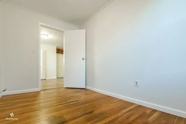 a view of an empty room with wooden floor