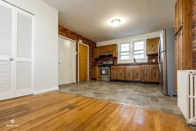 a view of a kitchen with stainless steel appliances granite countertop a refrigerator and a stove top oven