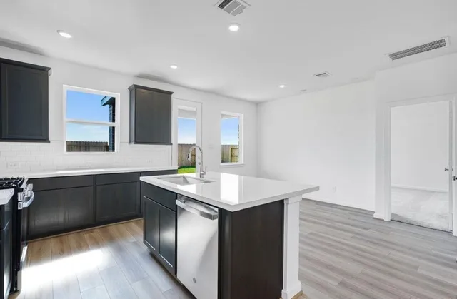 a kitchen with a sink cabinets and wooden floor