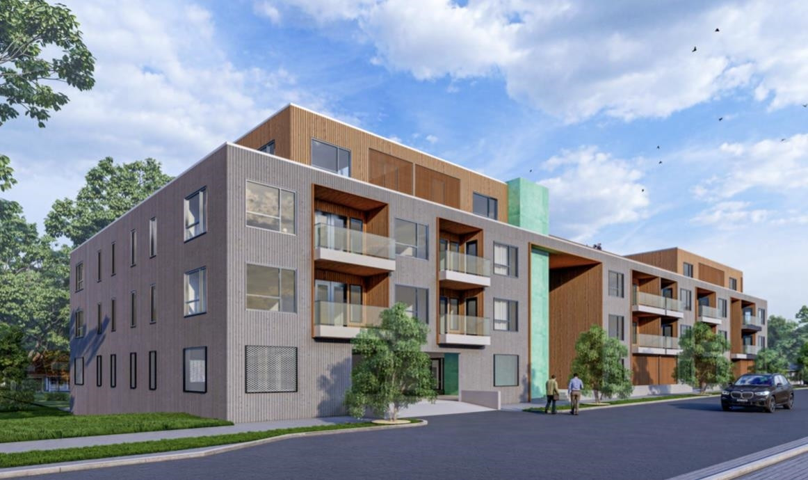 a front view of a building with lot of cars and trees