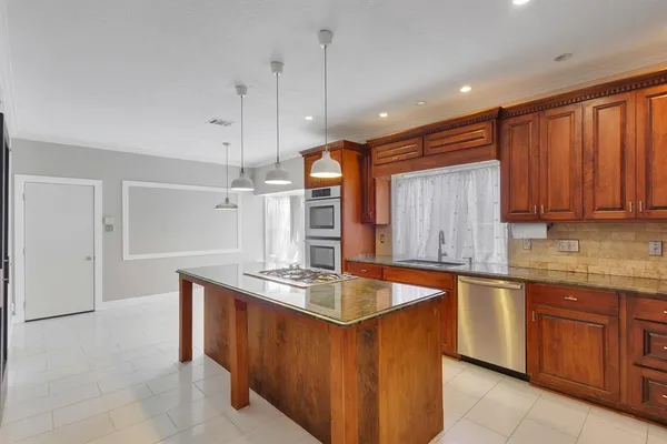 a kitchen with stainless steel appliances granite countertop a sink stove and refrigerator