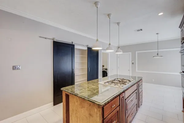 a kitchen with a stove a refrigerator a sink dishwasher with a dining table and chairs