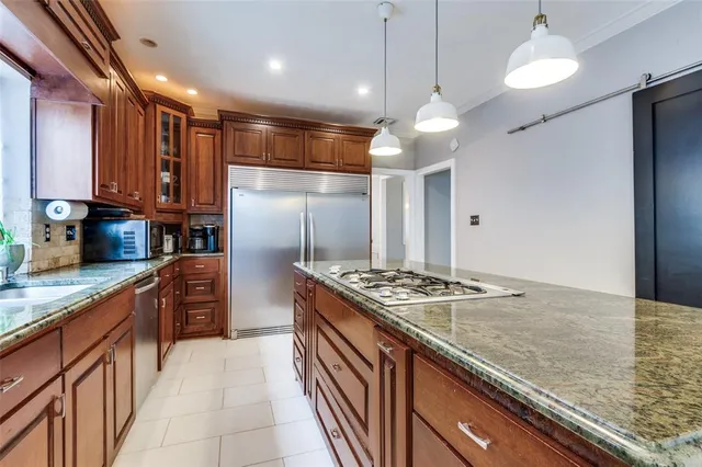 a kitchen with stainless steel appliances granite countertop a stove a refrigerator a sink and dishwasher